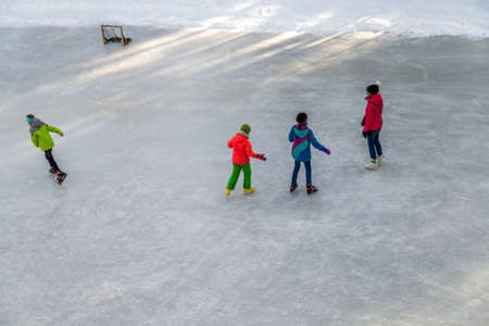 BADIA (BZ), ITALY - FEBRUARY 9, 2019: Boys and girls have fun skating on the ice in the Dolomites