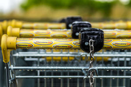 RUSSI (RA), ITALY - MAY 27, 2019: sunlight is enlightening and raindrops are covering the logo of Mercatone Uno on shopping carts on a gloomy day. Company went bankrupt last weekのeditorial素材