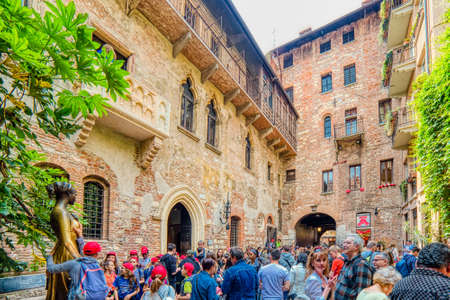 VERONA (VR), ITALY - MAY 10, 2019: tourists visiting the House of Juliet in Verona and touching the breast of the statue for good luck in loveのeditorial素材