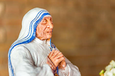 SAN BERNARDINO (RA), ITALY - MAY 20, 2019: sun is enlighetning the statue of Saint Mother Teresa of Calcutta praying in parish churchのeditorial素材