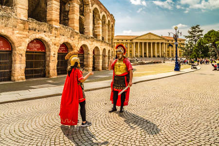 VERONA (VR), ITALY - MAY 10, 2019: tourists visiting Verona Arena while actors in Roman costumes are chattingのeditorial素材