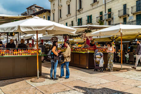 VERONA (VR), ITALY - MAY 10, 2019: tourists visiting the famous Piazzale delle Erbe, Herbs Square, and its typical market in Veronaのeditorial素材