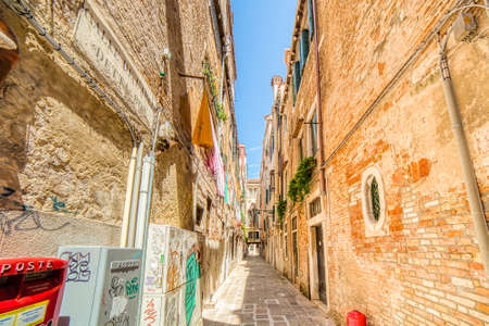 VENEZIA, ITALY â MAY 31, 2019: sunlight enlightening laundry drying on line in Calle De L'Arco, typical narrow street of Veniceのeditorial素材