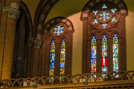 BOLOGNA, ITALY - MAY 10, 2019: sunlight is enlightening stained glasses of the Catholic Church of...