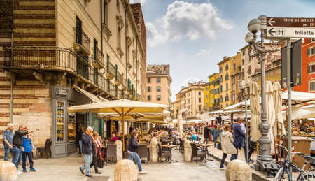 VERONA (VR), ITALY - MAY 10, 2019: tourists visiting the famous Piazzale delle Erbe, Herbs Square, and its typical market in Veronaのeditorial素材