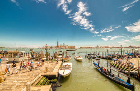VENEZIA, ITALY â MAY 31, 2019: tourists visiting the city and enjoying the view of  Saint James Island and boats passing in sea from  Riva degli Schiavoni near Saint Mark's Square in Veniceのeditorial素材