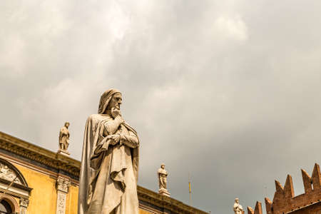 VERONA (VR), ITALY - MAY 10, 2019: sunlight is enlightening statue of Dante Alighieri holding his chin in Piazza dei Signori in Veronaのeditorial素材