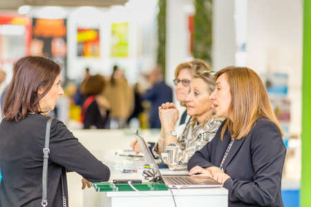 BOLOGNA (BO), ITALY - APRIL 12, 2019: exhibitor is welcoming visitor at Cosmofarma Exhibition, the...