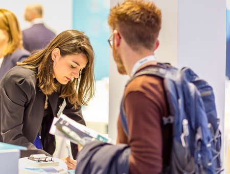 BOLOGNA (BO), ITALY - APRIL 12, 2019: exhibitor is welcoming visitor at Cosmofarma Exhibition, the...