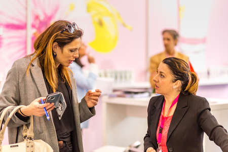 BOLOGNA (BO), ITALY - APRIL 12, 2019: exhibitor is welcoming visitor at Cosmofarma Exhibition, the...