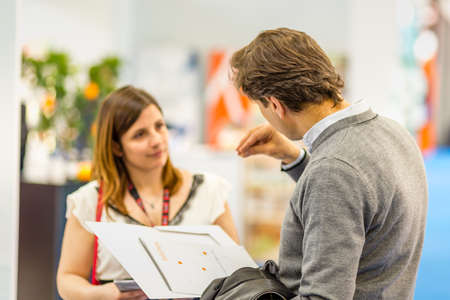 BOLOGNA (BO), ITALY - APRIL 12, 2019: exhibitor is welcoming visitor at Cosmofarma Exhibition, the...