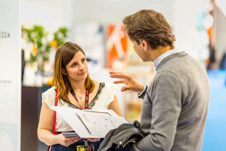 BOLOGNA (BO), ITALY - APRIL 12, 2019: exhibitor is welcoming visitor at Cosmofarma Exhibition, the pharmacy worldâs leading Europeanのeditorial素材