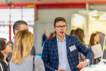 BOLOGNA (BO), ITALY - APRIL 12, 2019: exhibitor are welcoming visitor at Cosmofarma Exhibition, the...