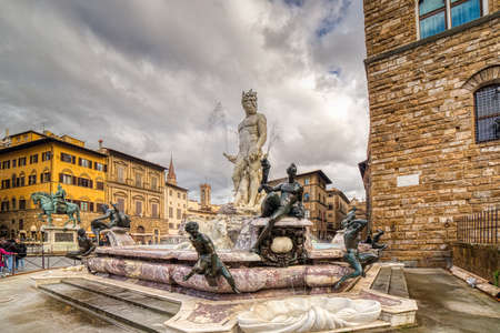 FLORENCE, ITALY - DECEMBER 15, 2019: sunlight enlightening statue of Neptune in SIgnoria Square in Florence  in Tuscany, Italyのeditorial素材