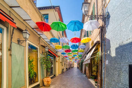 RAVENNA, ITALY - JUNE 19,2019:  wind waving colorful hanging umbrellas in street of historical center of Ravennaのeditorial素材