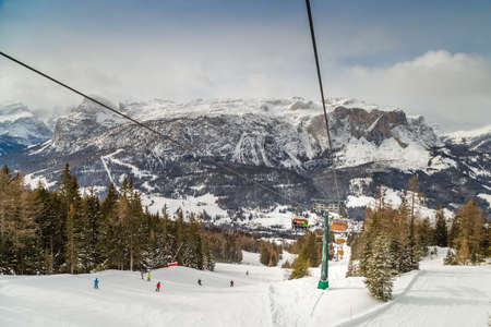 BADIA (BZ), FEBRUARY 11, 2019: chairlift seats running through snow covering wood
