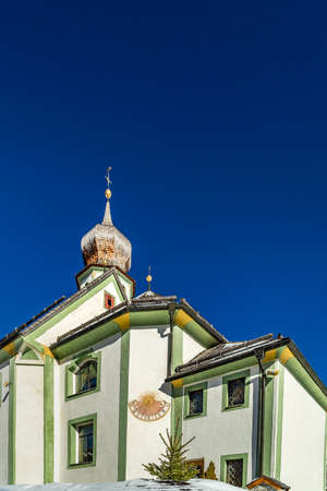 San Cassiano (BZ), February 12, 2019: sunlight is enlightening the parish churchの写真素材