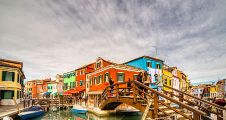 BURANO (VE), ITALY - FEBRUARY 21, 2020: tourists walking along the colorful houses of the ancient fishing villageのeditorial素材