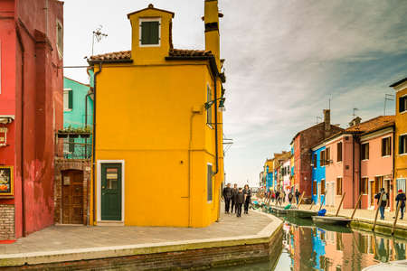BURANO (VE), ITALY - FEBRUARY 21, 2020: tourists walking along the colorful houses of the ancient fishing villageのeditorial素材