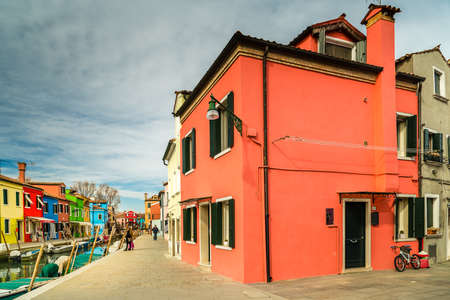 BURANO (VE), ITALY - FEBRUARY 21, 2020: tourists walking along the colorful houses of the ancient fishing village during Carnivalのeditorial素材