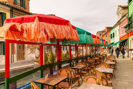 BURANO (VE), ITALY - FEBRUARY 21, 2020: tourists walking along the colorful houses of the ancient fishing village during Carnivalのeditorial素材
