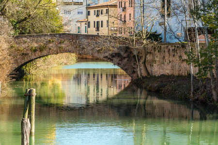 PADOVA, ITALY - FEBRUARY 23, 2019: sunlight is enlightening typical architecture of buildings on water channel in historical center in Padovaのeditorial素材