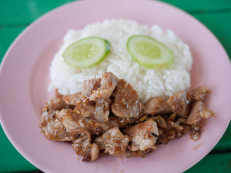 rice and fried pork with garlic on white plate の写真素材
