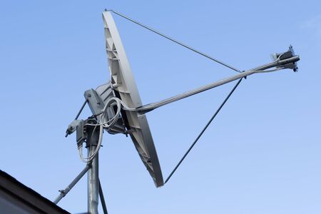 White satellite dish with blue skyの写真素材