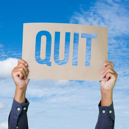 Two hands holding brown cardboard with quit overhead on blue sky background