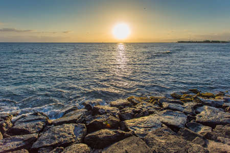 Sea wave hit the rock at sunset in Hawaii