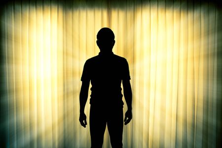 Silhouette of man standing with light ray effect backgroundの写真素材