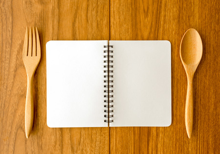 Blank notebook fork spoon on wood backgroundの写真素材
