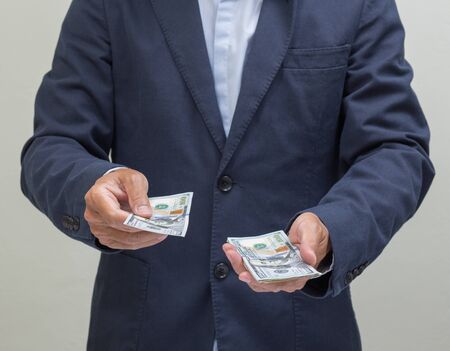 Businessman with hands giving dollar banknote, US dollarsの写真素材