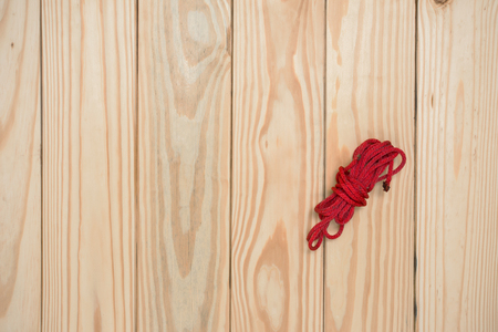Red rope on wood tableの写真素材