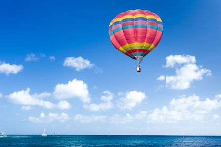 Colorful hot air balloon over blue seaの写真素材