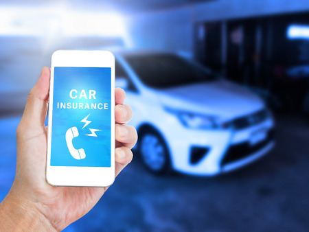Hand holding mobile phone with Car insurance on screenの写真素材