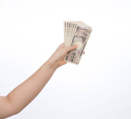 Hand holding Japanese banknote on white background. Japanese money.の写真素材