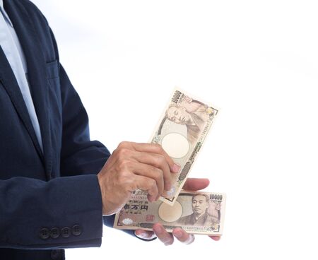 Hand holding Japanese banknote on white background. Japanese money.