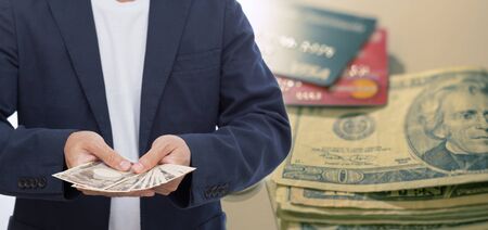Hand holding Japanese banknote on blur us. dollar and credit card background