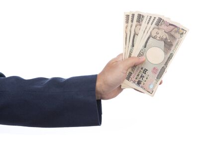Hand holding Japanese banknote on white background. Japanese money.