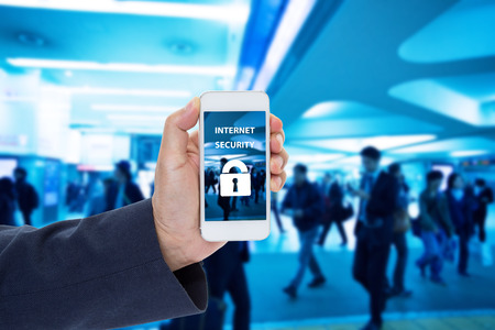Hand holding mobile phone with Internet security on screen