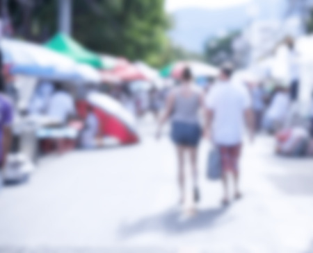 Blurred image of people walking around street market use for backgroundの写真素材