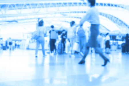 People traveling at airport terminal in blurred motion with retro color effected, Abstract blur people backgroundの写真素材
