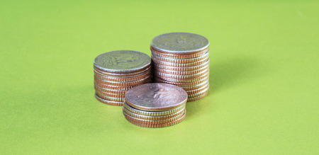 Stack of coins on green background