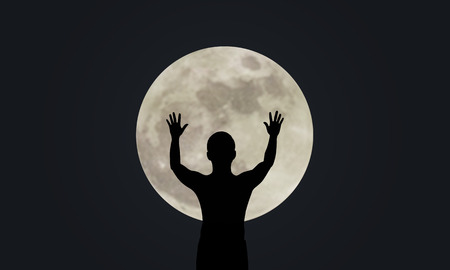 Silhouette man show his hand up with Super full moon nightの写真素材