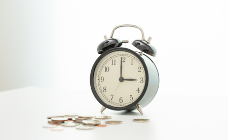 Vintage clock at three o'clock and coinsの写真素材