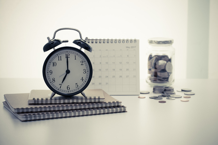 Vintage clock ring binder notebook calendar and coins with retro color effectedの写真素材