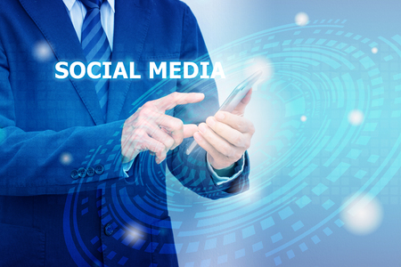 Social media concept with double exposure of businessman hand and digital technology graphic backgroundの写真素材