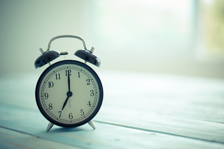 Vintage clock on wood background. Time at seven o'clockの写真素材