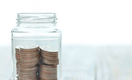 Bottle of coins on vintage wood background